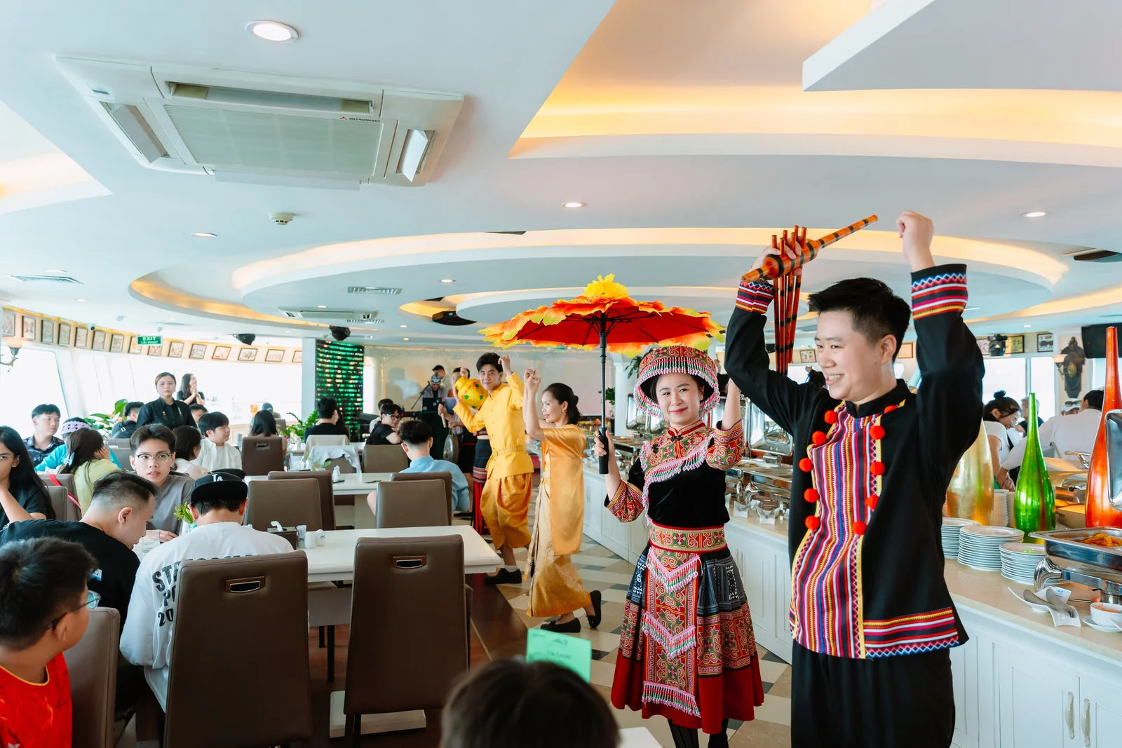 Nghệ sĩ trình diễn trang phục dân tộc H'Mông cùng chiếc ô đỏ trong nhà hàng trên du thuyền Hạ Long Princess Day Cruise