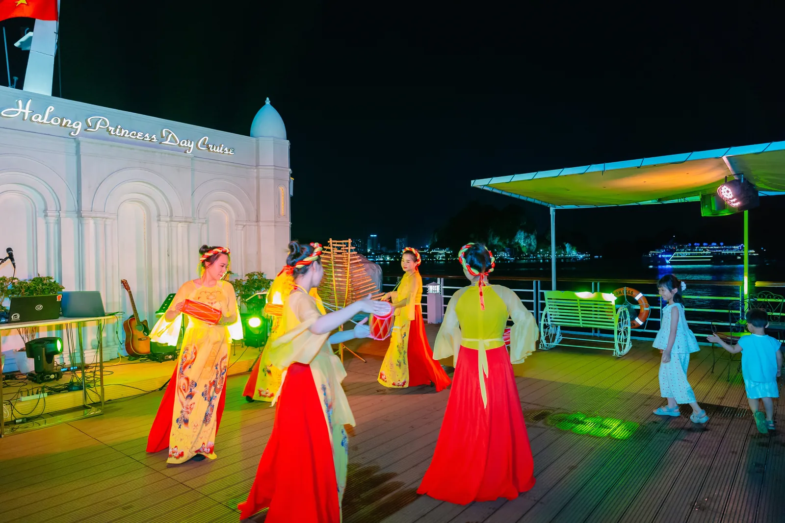 Đoàn nghệ sĩ múa dân gian trong trang phục truyền thống biểu diễn trên sân khấu Sundeck du thuyền Hạ Long Princess