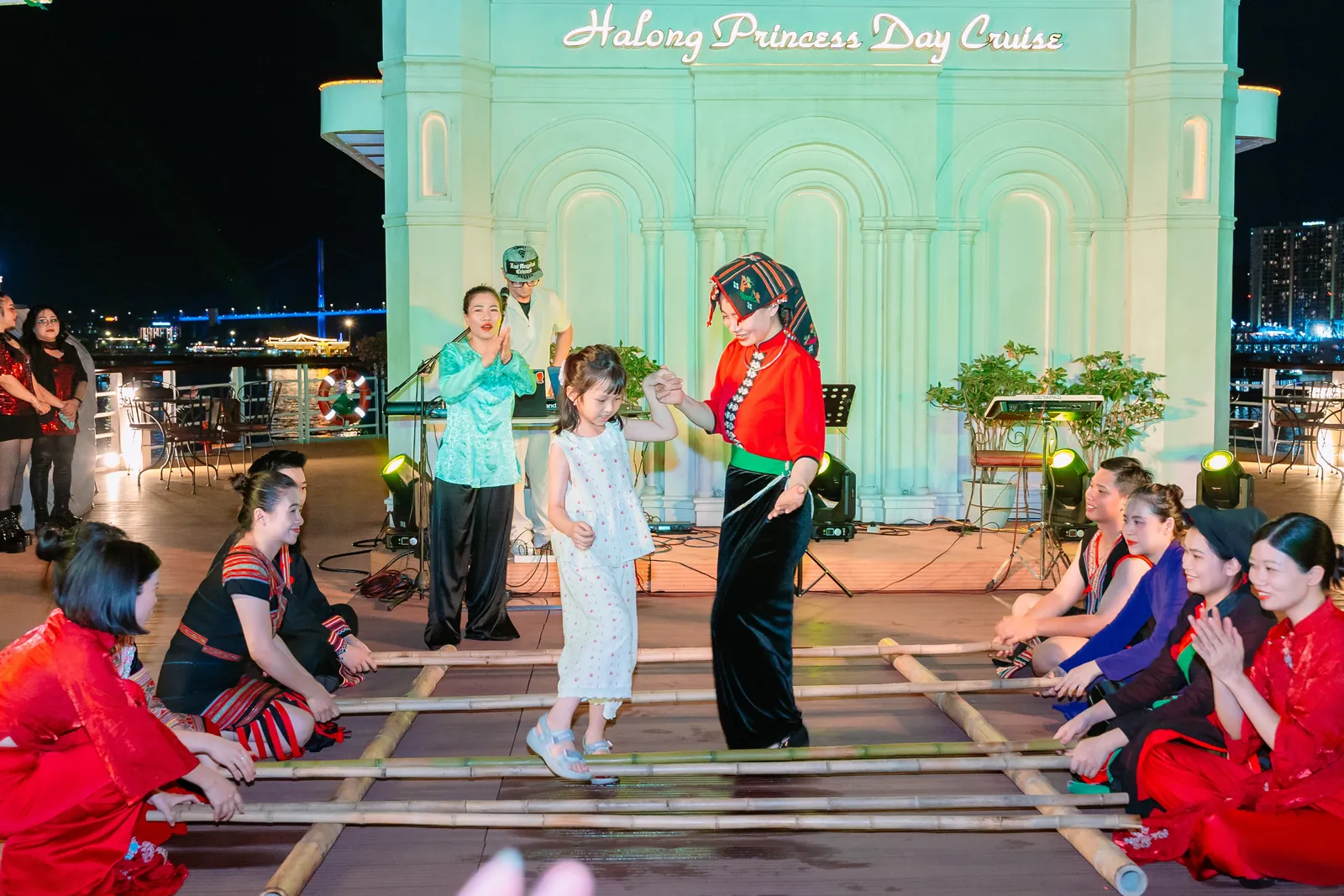 Nghệ sĩ hướng dẫn du khách nhí nhảy sạp trong Sundeck Cultural Experience trên du thuyền Hạ Long Princess