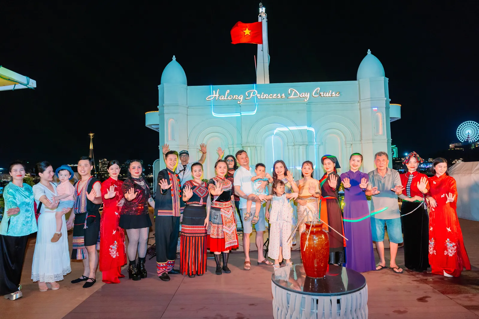 Du khách và nghệ sĩ chụp ảnh lưu niệm bên ché rượu cần trên du thuyền Hạ Long Princess