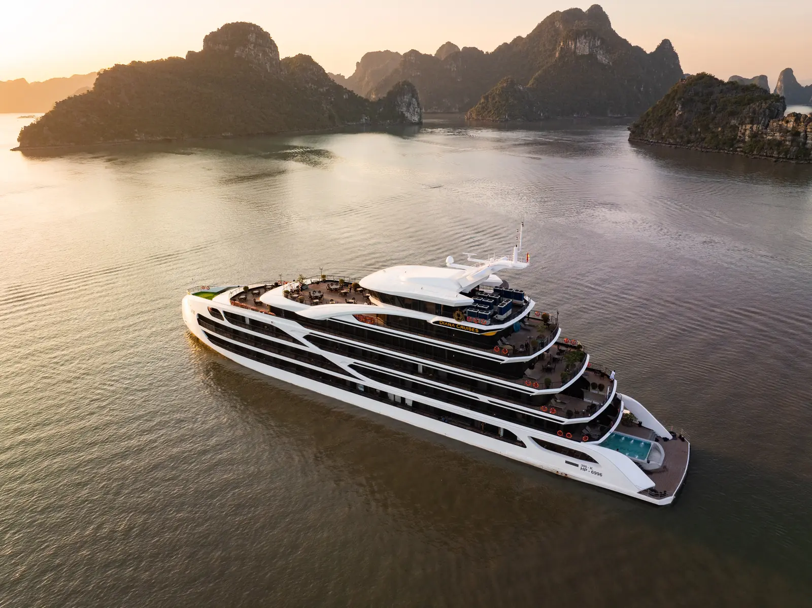 Du thuyền Diana Cruises nhìn từ trên cao, lướt giữa các đảo đá Vịnh Lan Hạ trong nắng sớm
