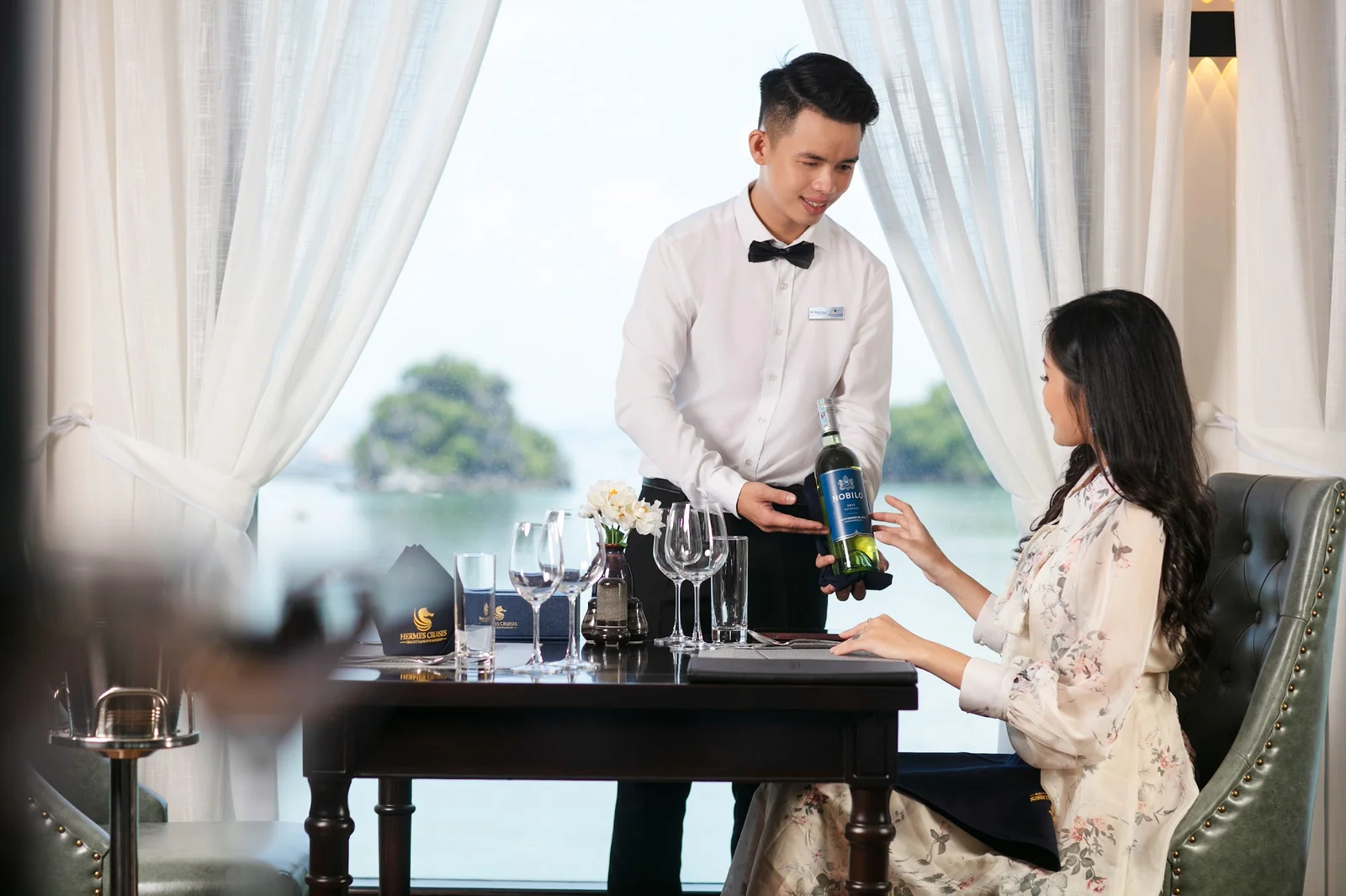 Nhân viên phục vụ giới thiệu rượu vang tại nhà hàng trên du thuyền Hermes