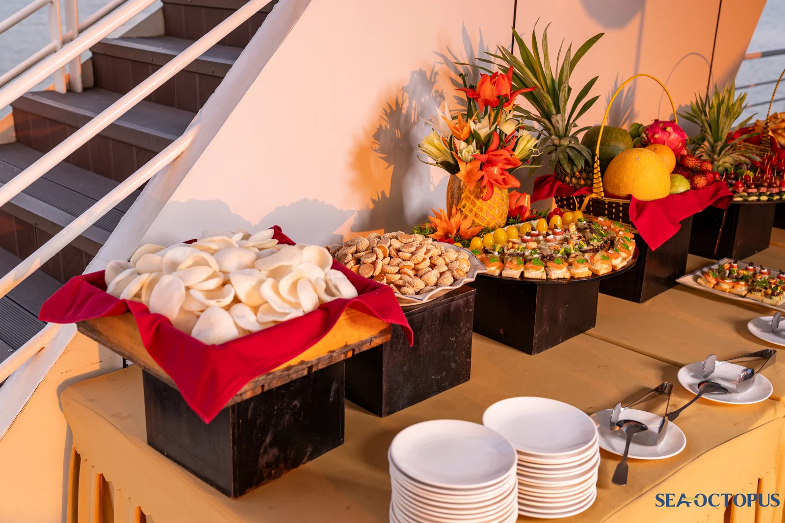 Bàn tiệc buffet canapé trang trí trái cây rực rỡ lúc hoàng hôn